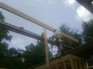 Carpenter setting a ridge beam over a new addition frame — Ice Dam Removal by Roofing Brothers in Rock Tavern