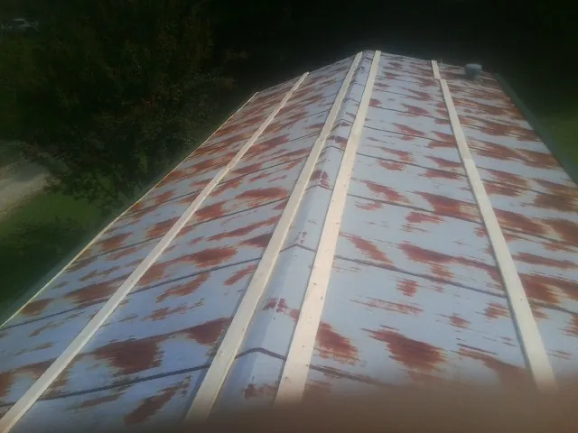 Rusted metal roof panels with new wood purlins before replacement — Storm Damage Roof Repair in Rock Tavern by Roofing Brothers